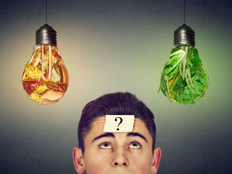 man with question looking at junk food vegetables light bulbs